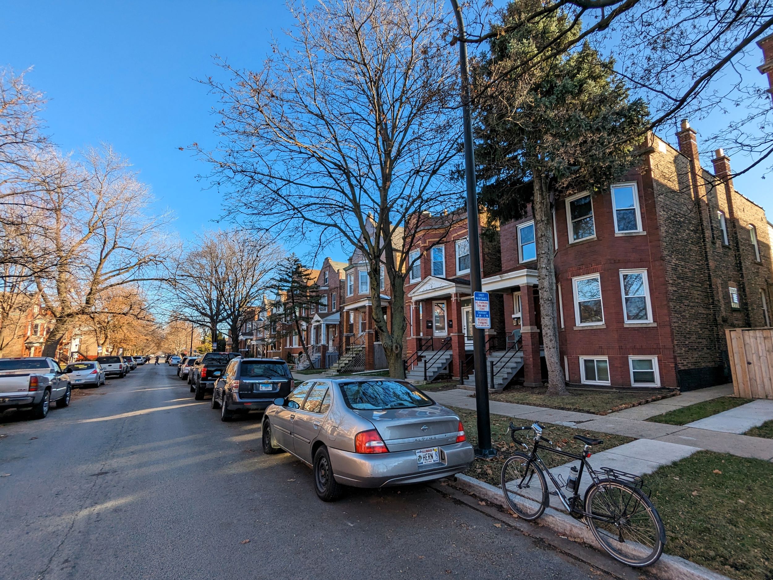 A tour bicycle standing in front of a row of early 1900s two story brick single wo flats.