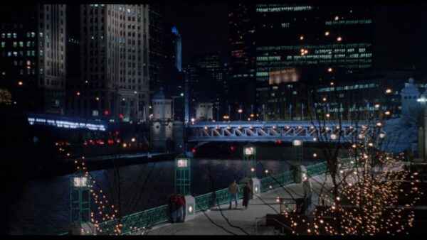 A movie still of Sandra Bullock and Bill Pullman walking along the Chicago River.