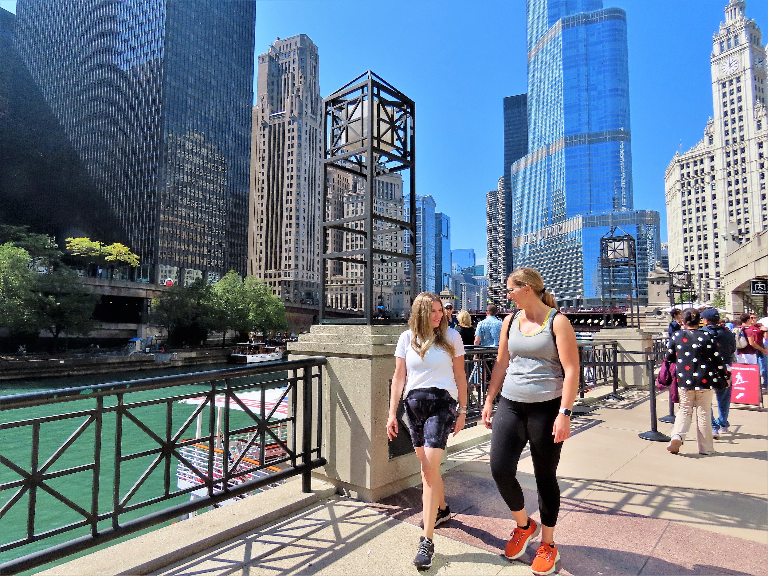 Two CBA riders walking and talking along the Chicago River