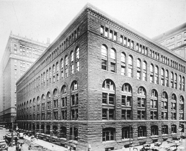 An historical black and white of Richardsonian granite seven story building taking up a city block.