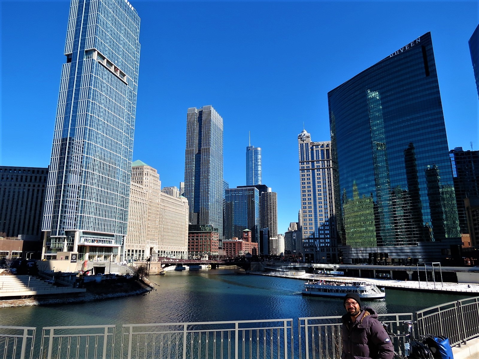 A CBA bike tour rider looking at the camera with the Chicago river confluence and skyscrapers behind.